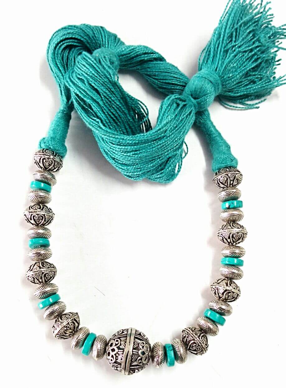 A necklace with beads and a tassel
