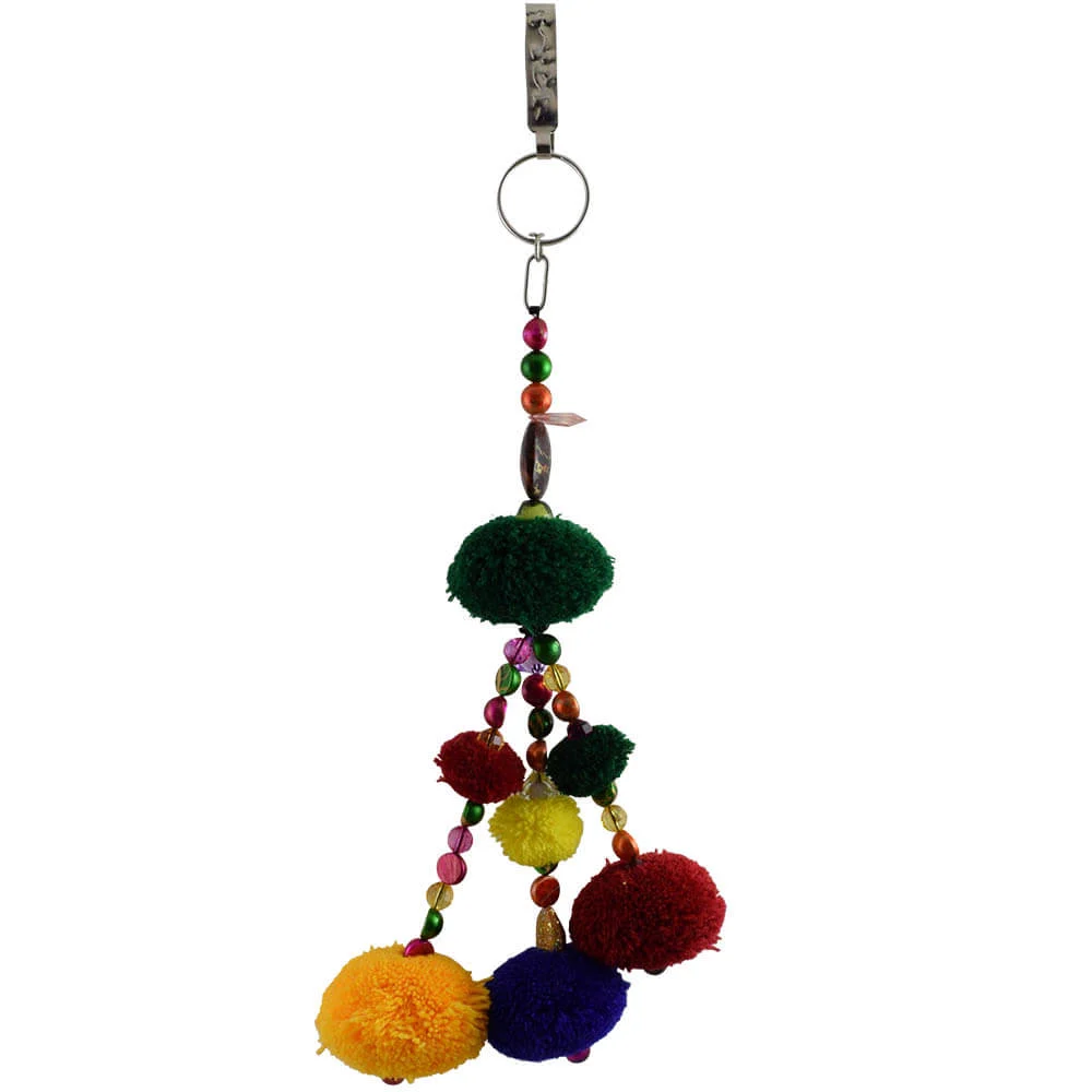 A multi colored pom pom hanging from a metal hook
