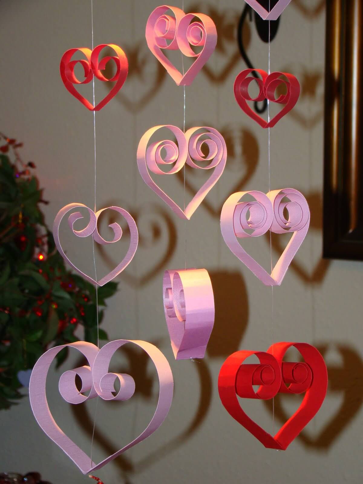 A group of paper hearts hanging from strings
