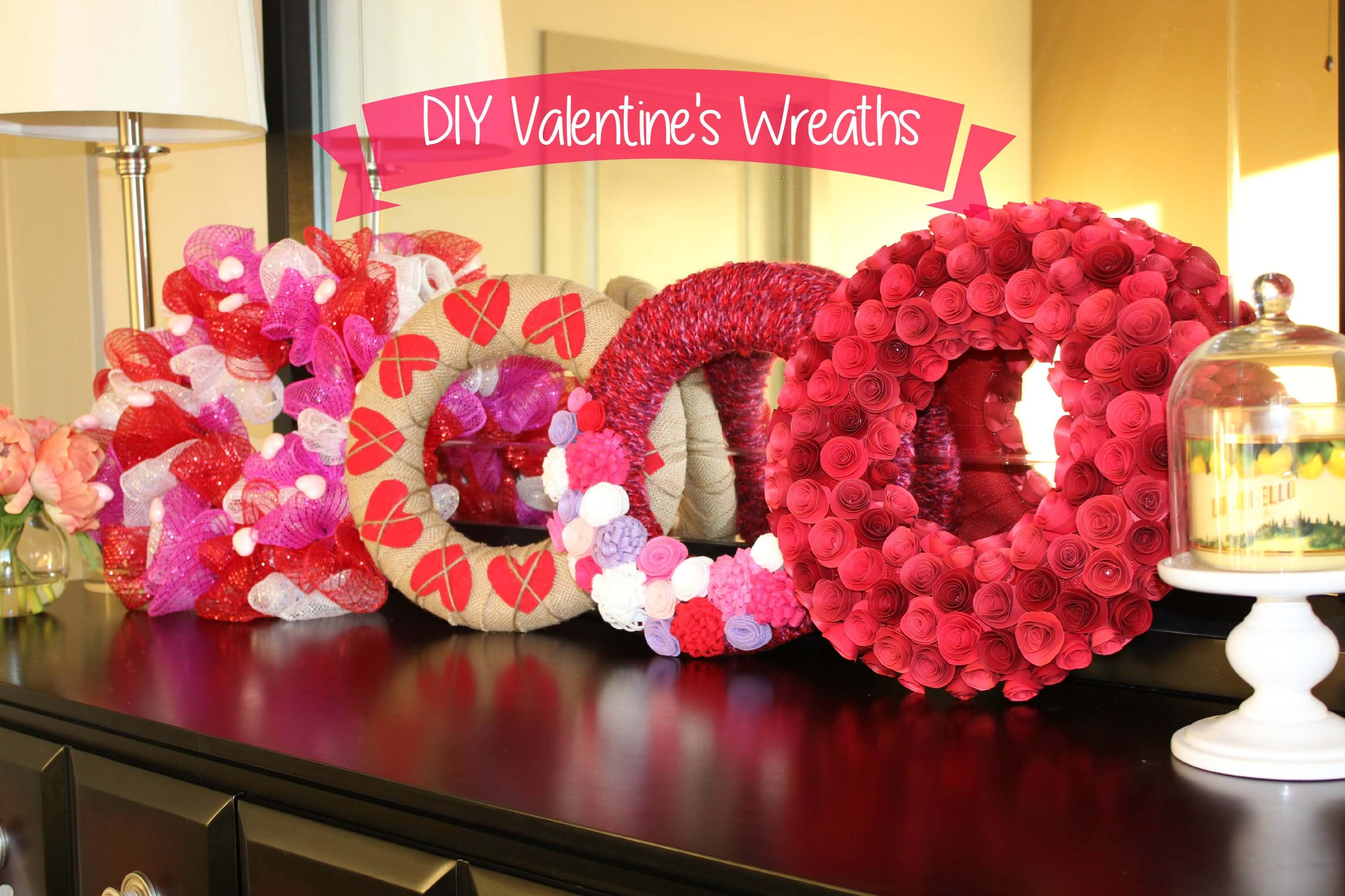 A wooden table topped with lots of valentine's wreaths
