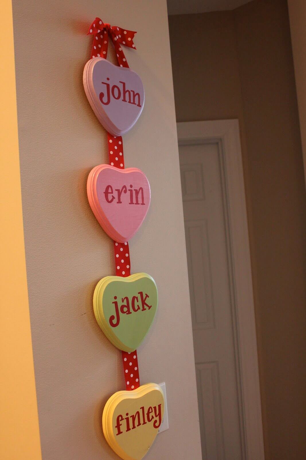 A wooden sign with hearts hanging on a wall
