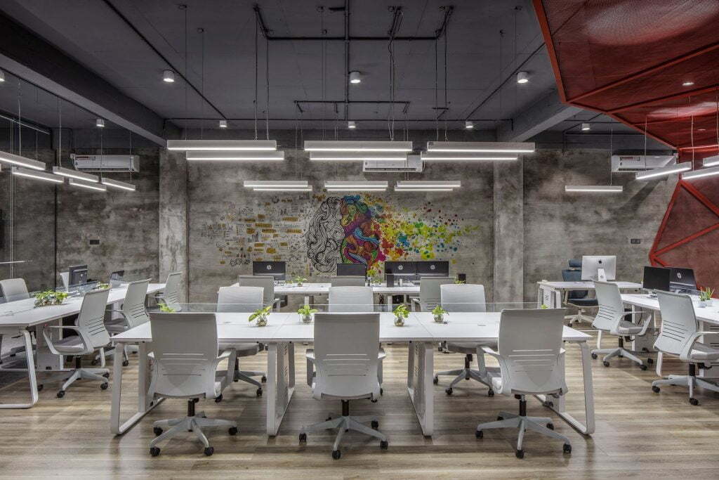 An office with a large white table and white chairs
