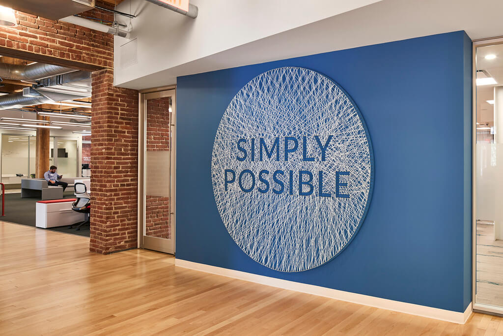 A sign that says simply possible on a blue wall
