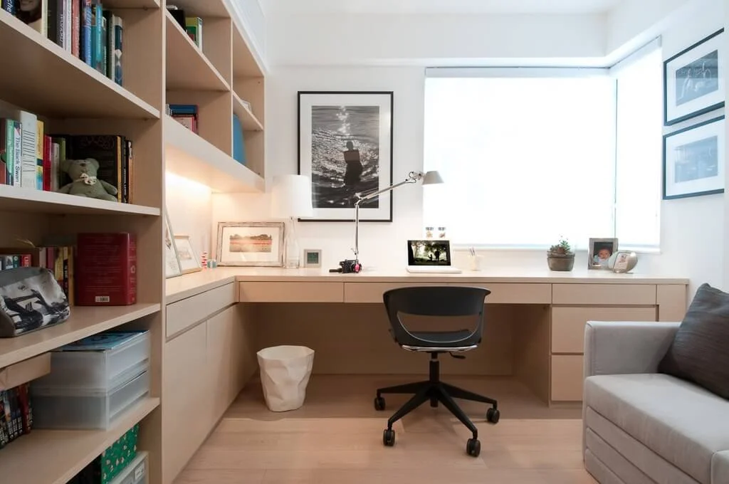 A room with a couch, desk, bookshelf and a chair
