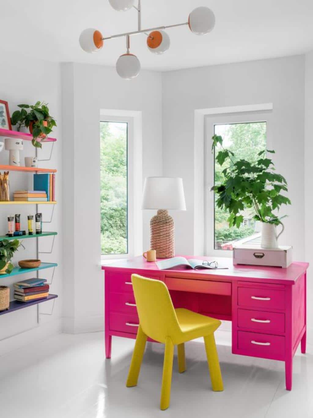 A pink desk with a yellow chair in a white room
