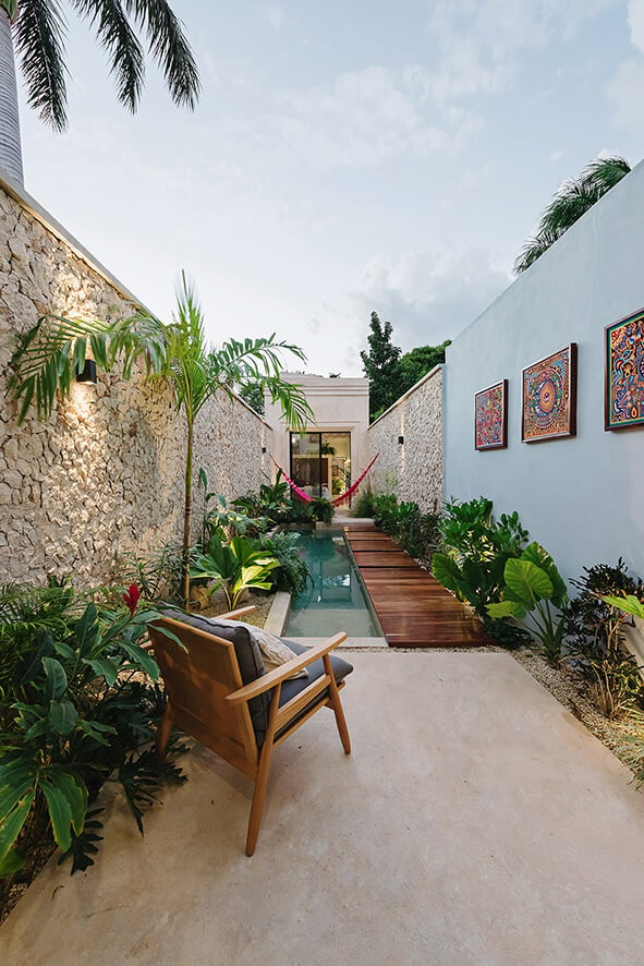 Casa Picasso : A patio with a wooden chair next to a pool
