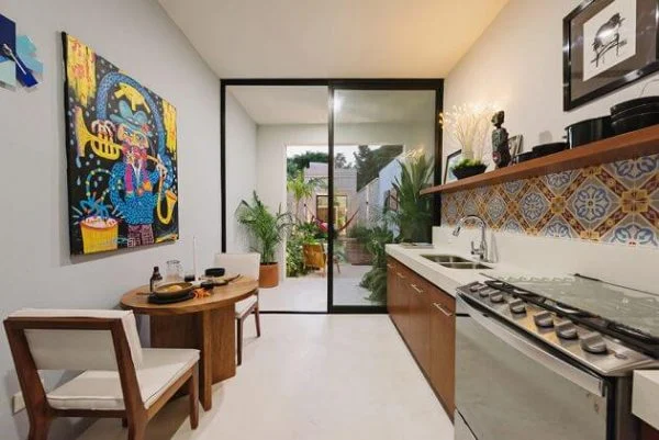 Casa Picasso  kitchen with a stove top oven next to a dining room table
