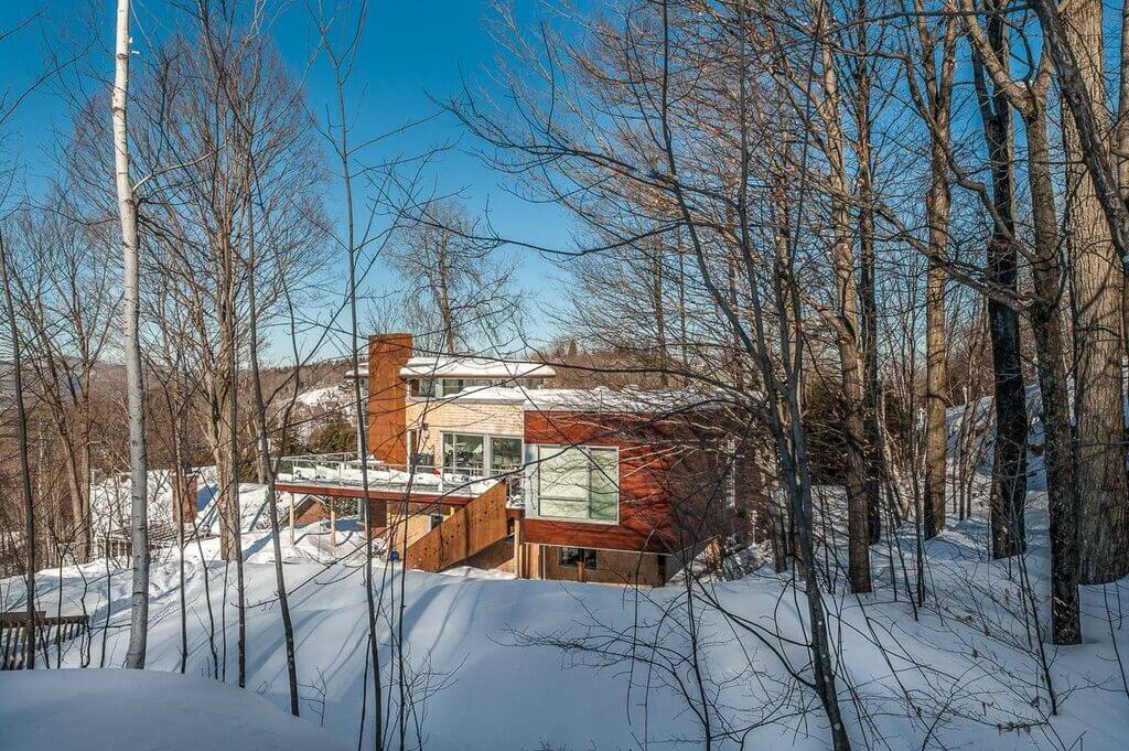 A house in the woods covered in snow
