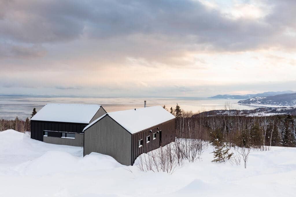 A barn in the middle of a snowy field
