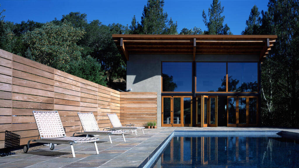 Two lawn chairs sitting next to a swimming pool
