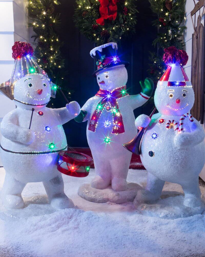 A couple of snowmen that are standing in the snow
