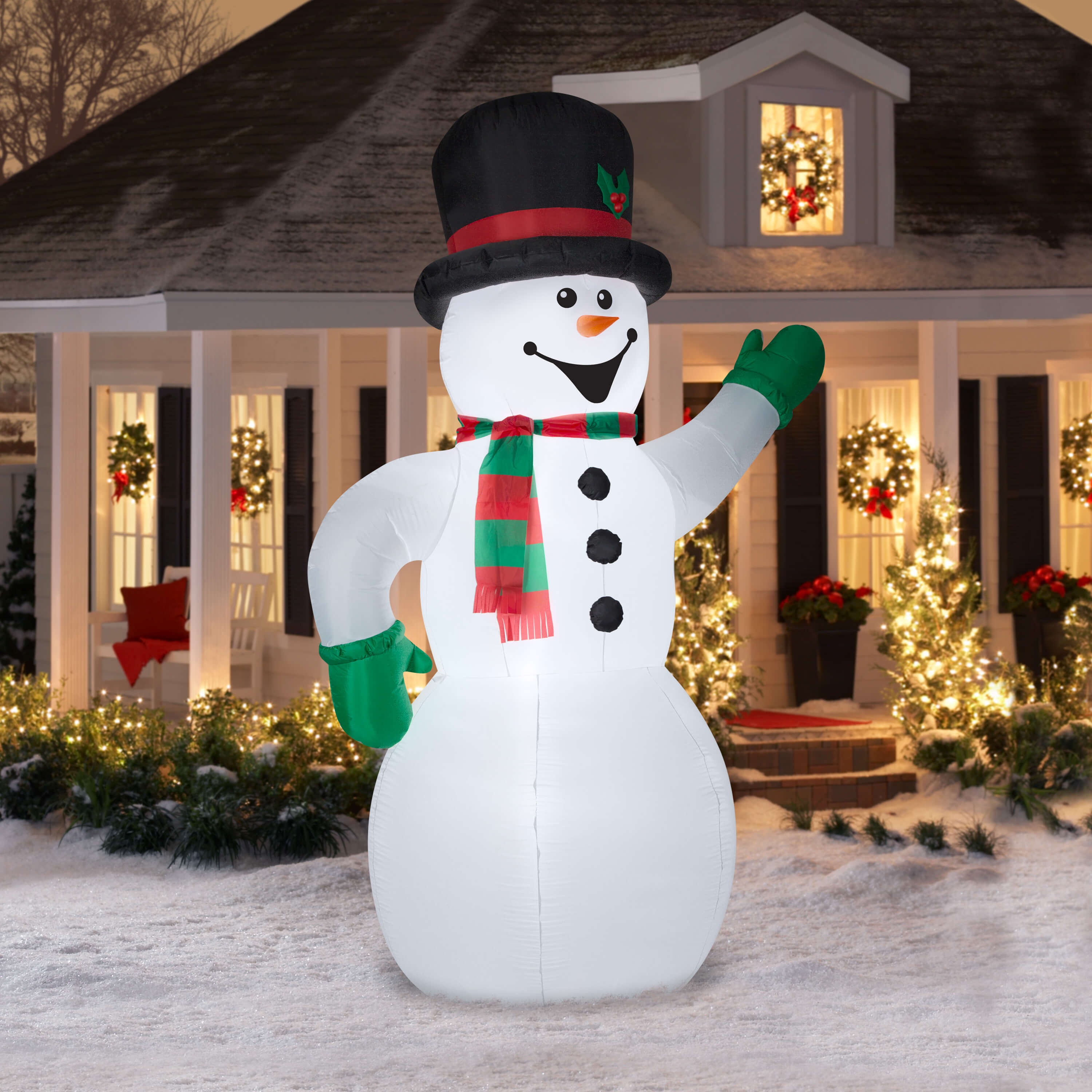 A large inflatable snowman standing in front of a house
