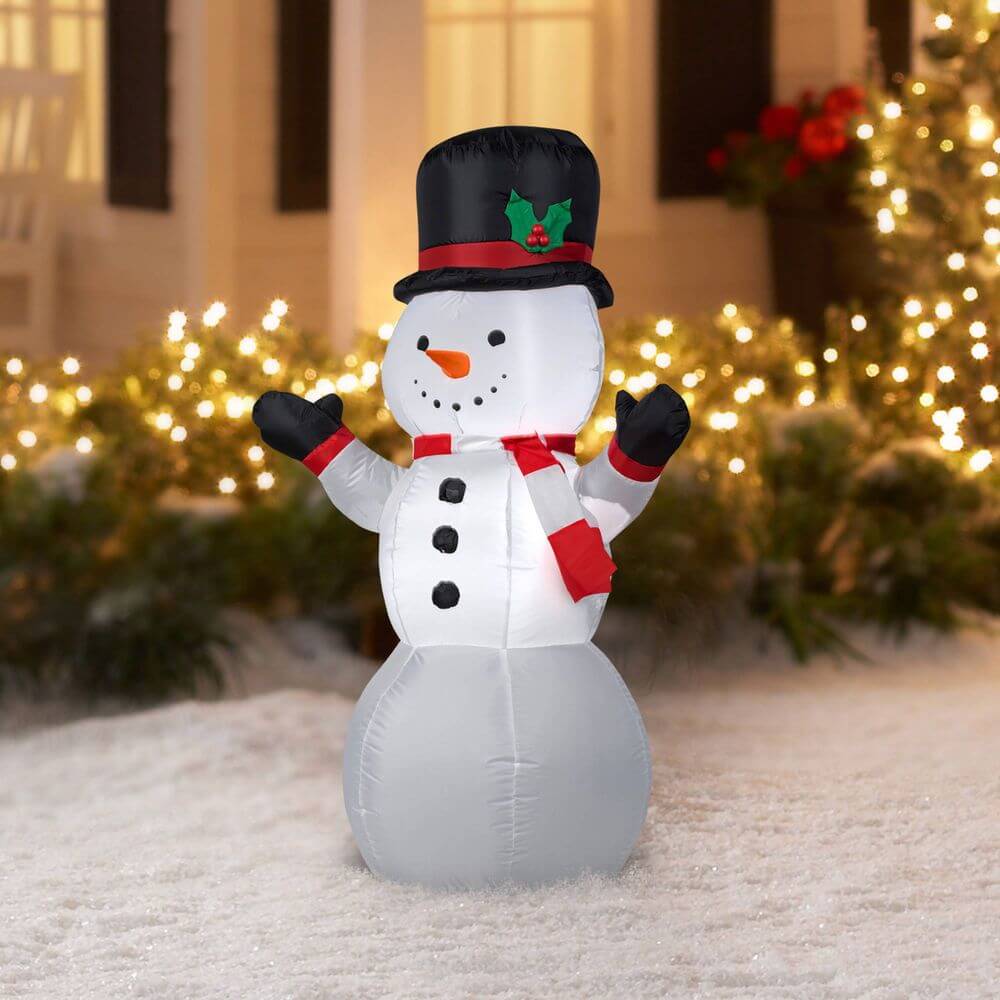 A large inflatable snowman in front of a house
