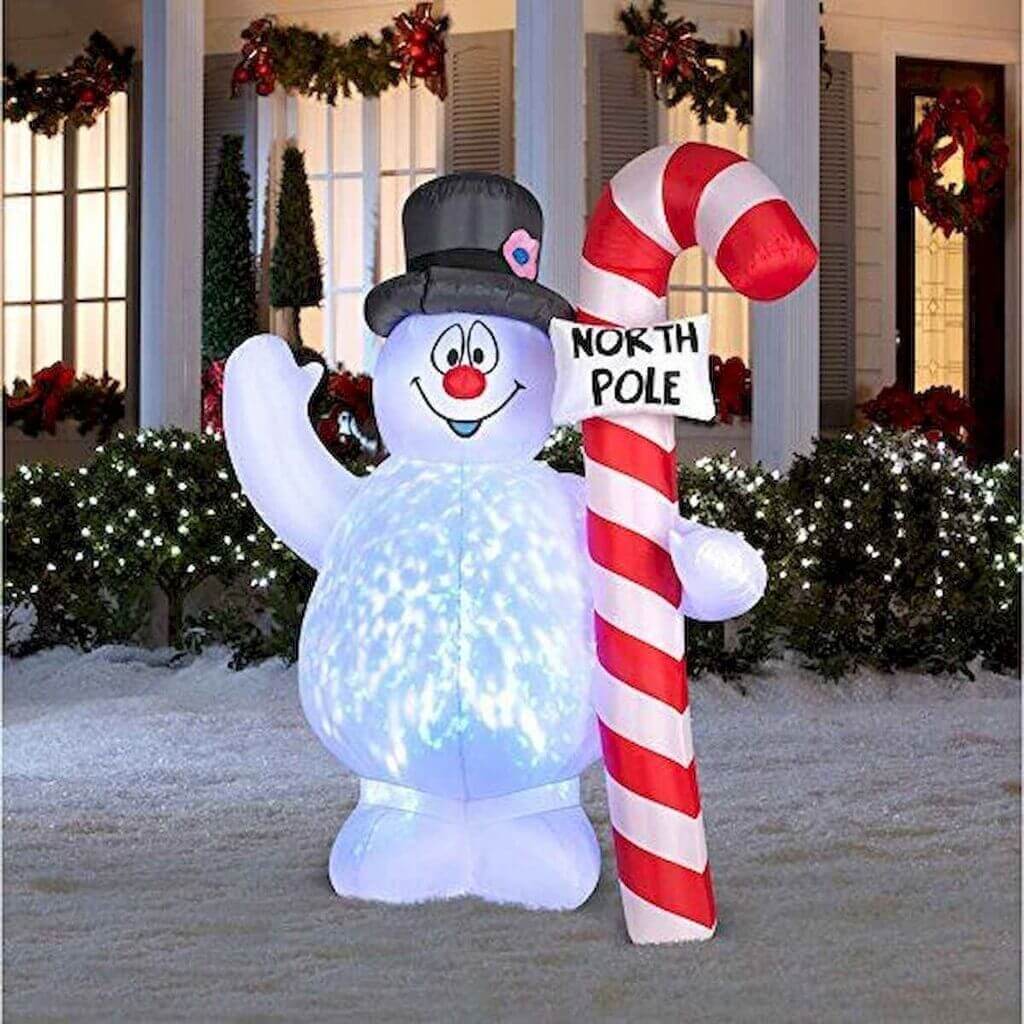 A large inflatable snowman holding a candy cane
