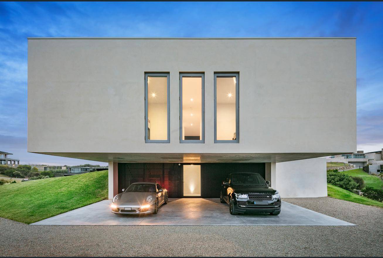 Two cars parked in front of a modern house
