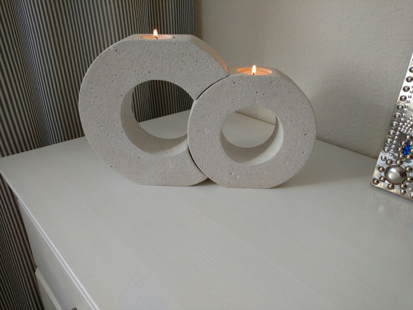 A couple of white candles sitting on top of a table
