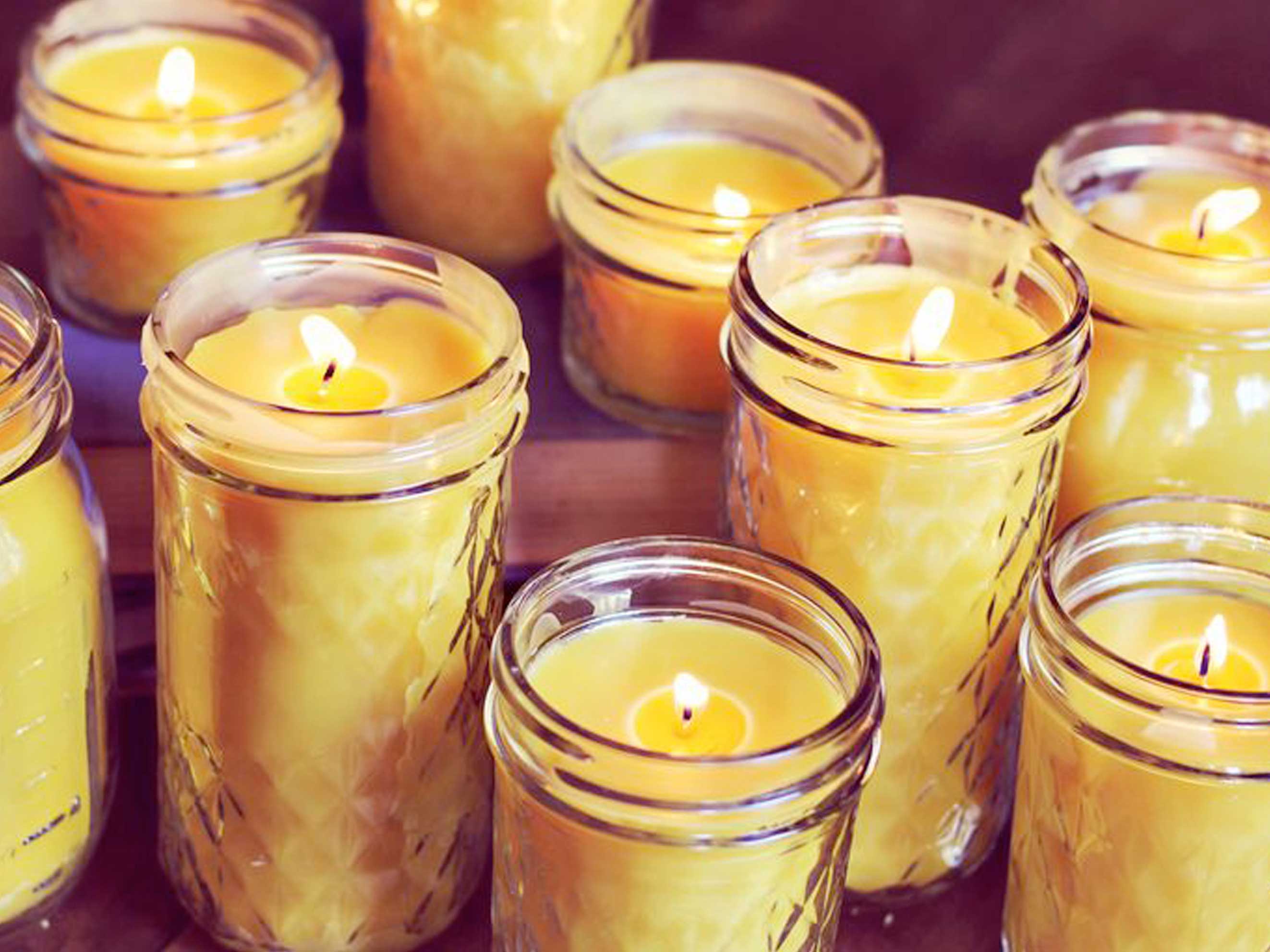 A group of yellow candles sitting on top of a table

