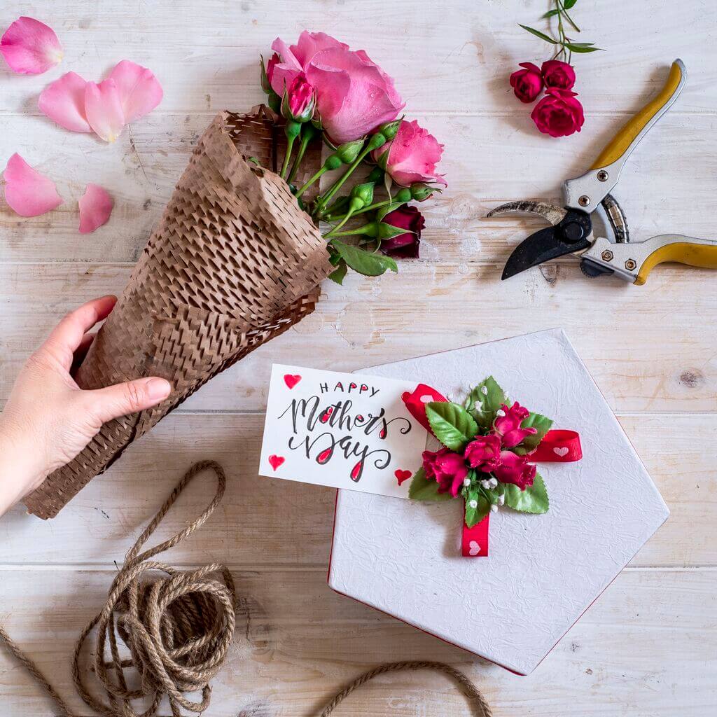 A person holding a bouquet of flowers next to a card
