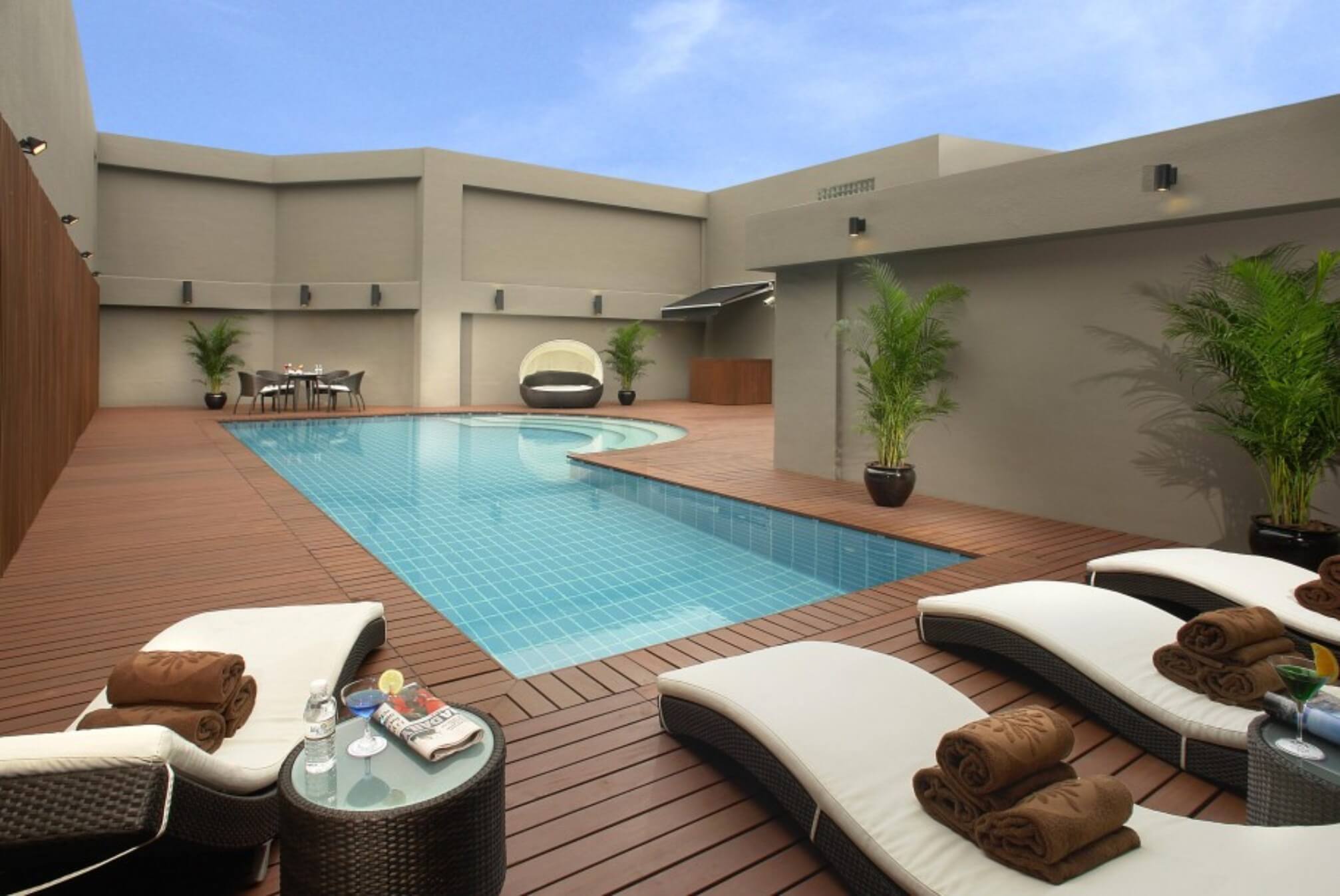 A swimming pool with lounge chairs and towels
