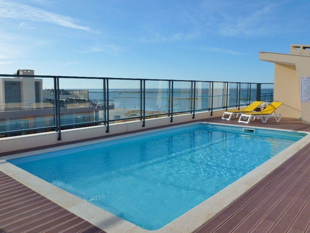 A swimming pool on a balcony overlooking the ocean
