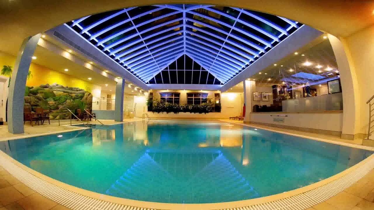 A large indoor swimming pool with a skylight
