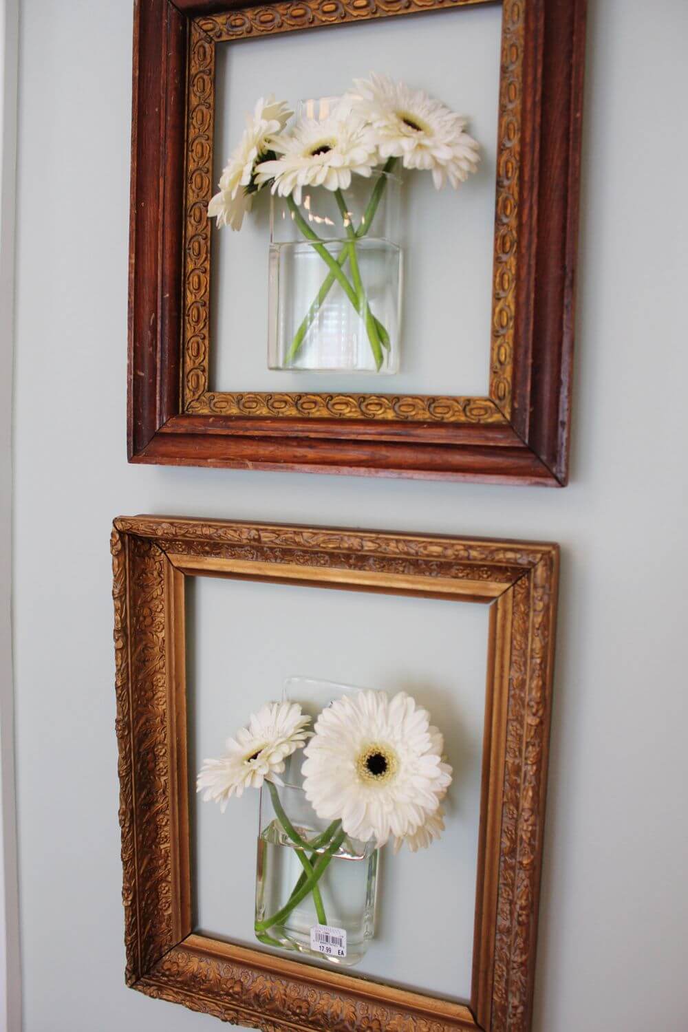 Two frames with flowers in them hanging on a wall
