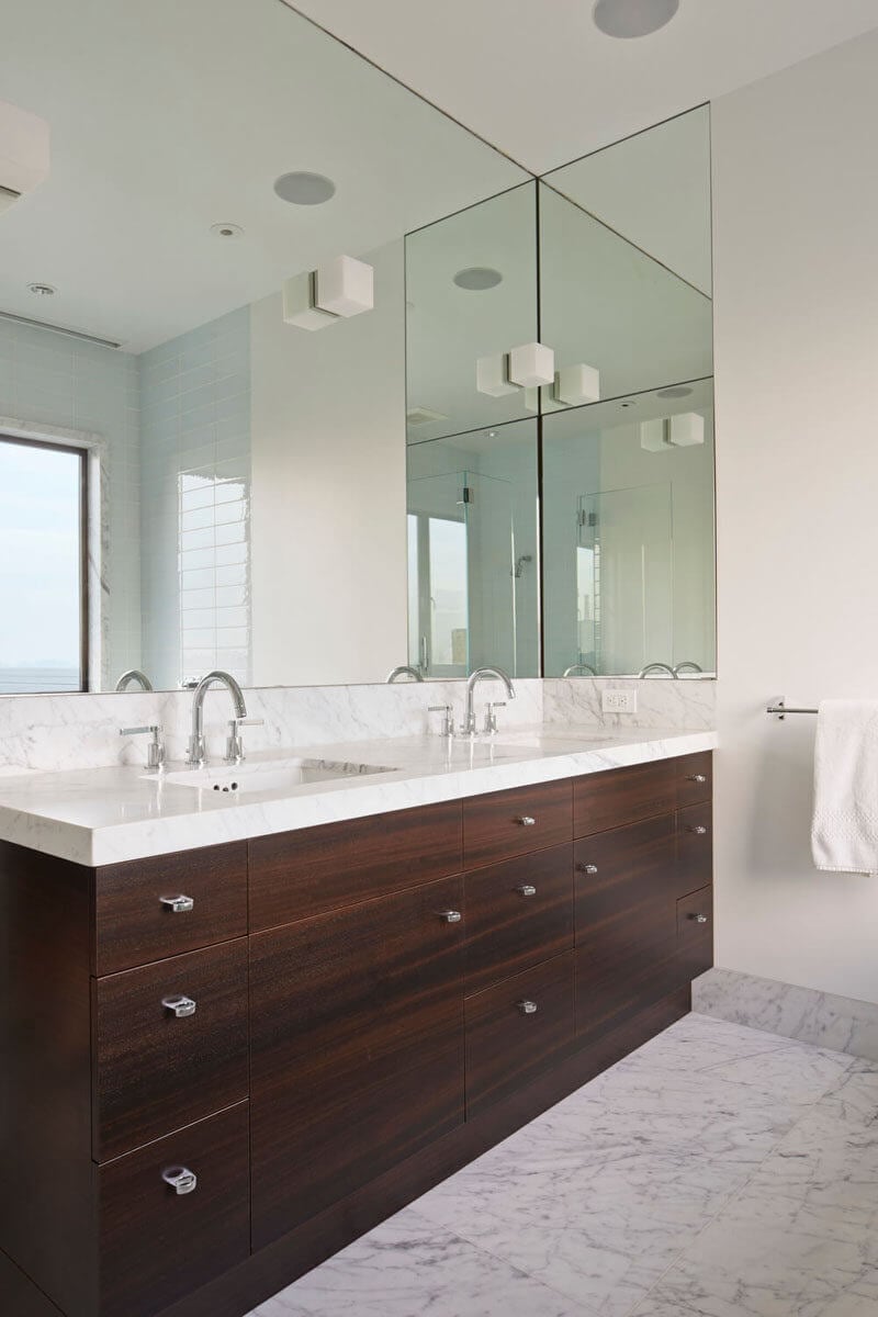 A bathroom with two sinks and a large mirror
