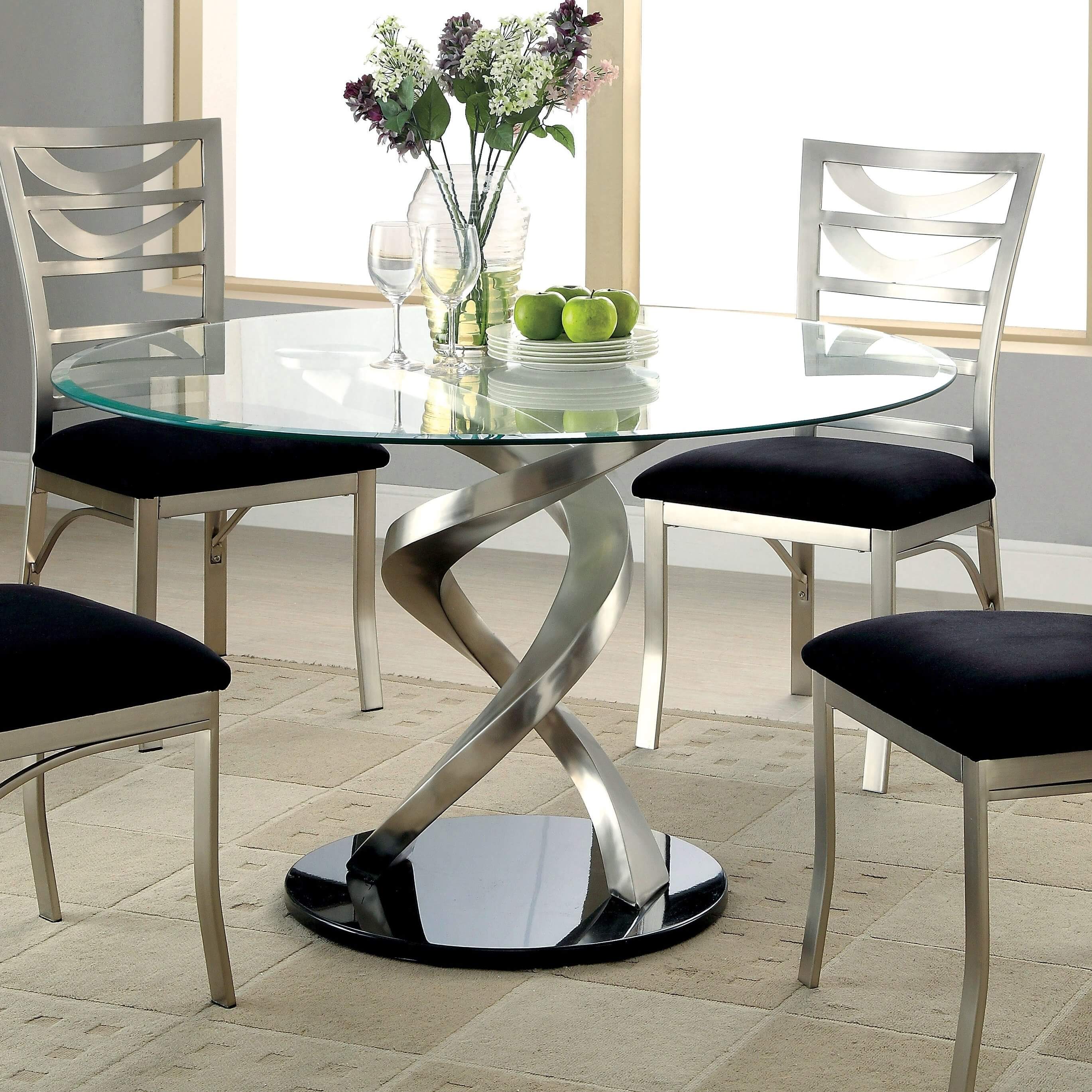 A glass dining table with a metal base
