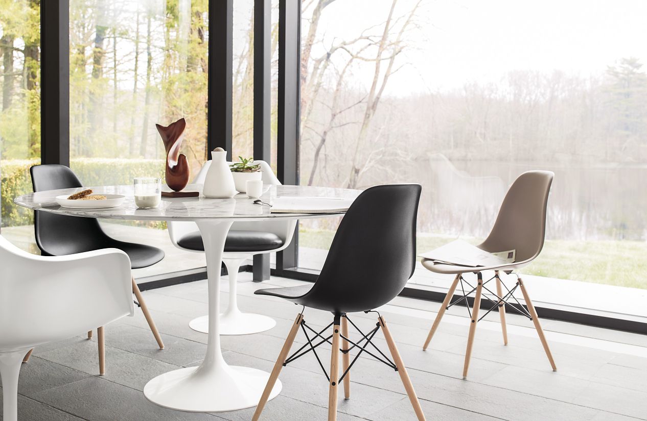 A round white table with four chairs around it
