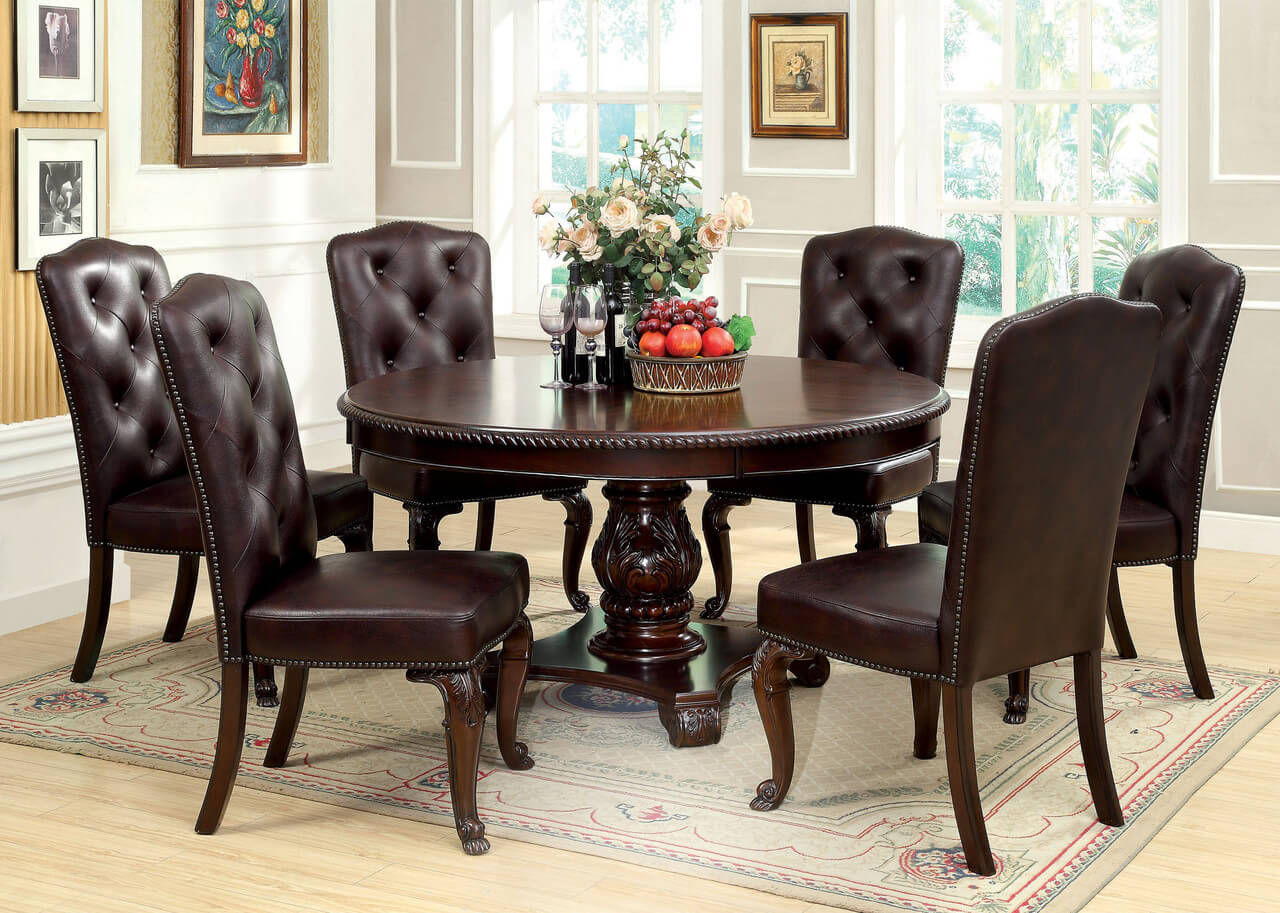 A round dining room table with a bunch of chairs around it
