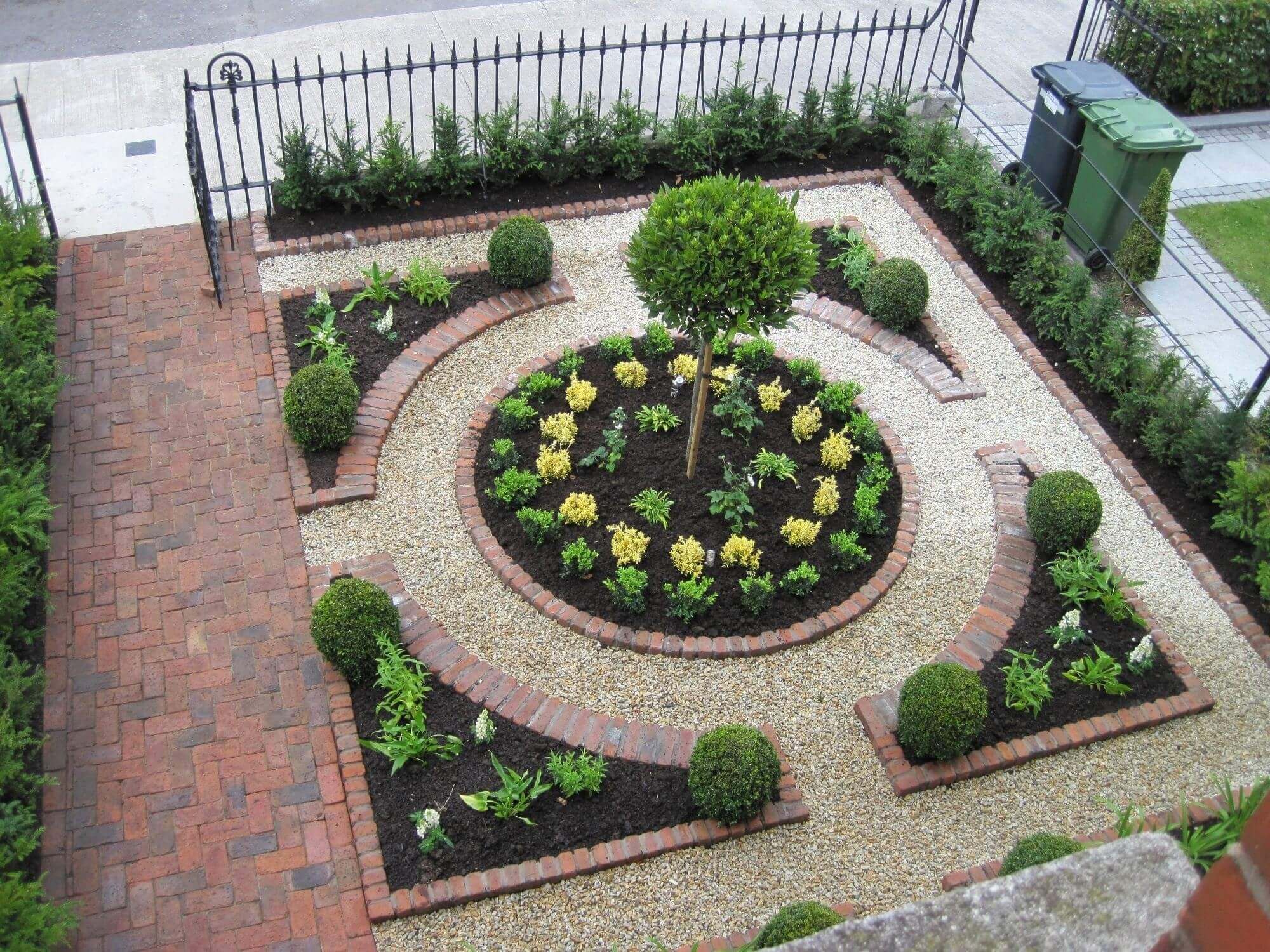 A garden with a circular garden design in the middle of it
