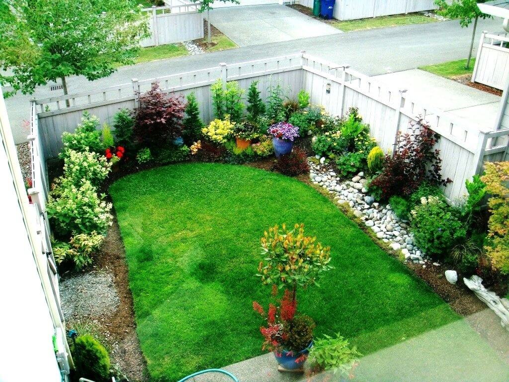 A small backyard with a lawn and flower garden
