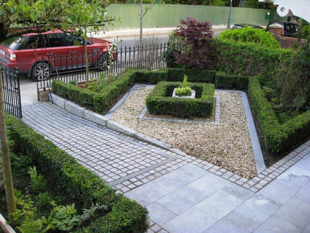 A red car is parked in the middle of a garden
