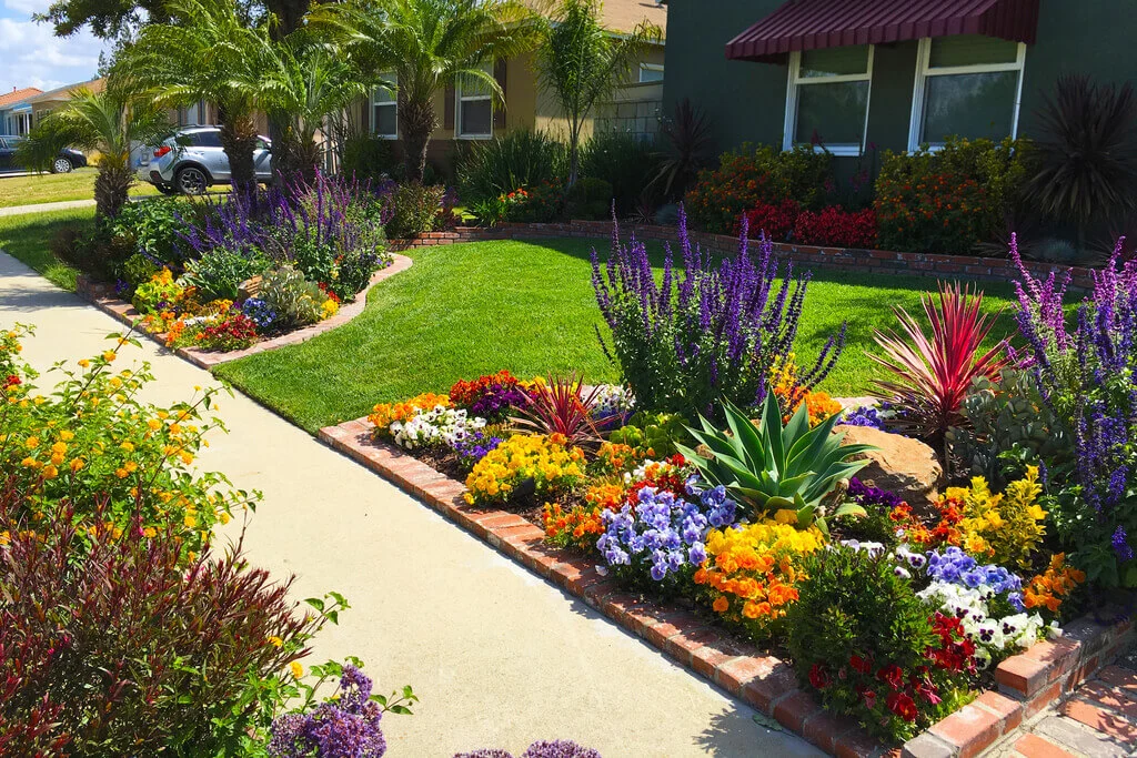 A flower garden in front of a house
