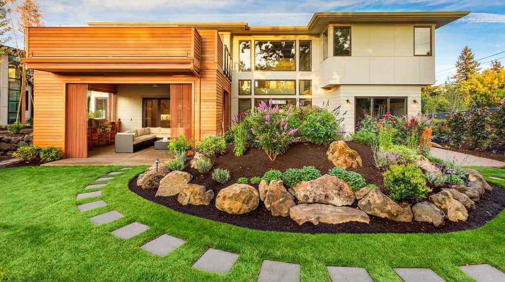 A house with a rock garden in front of it
