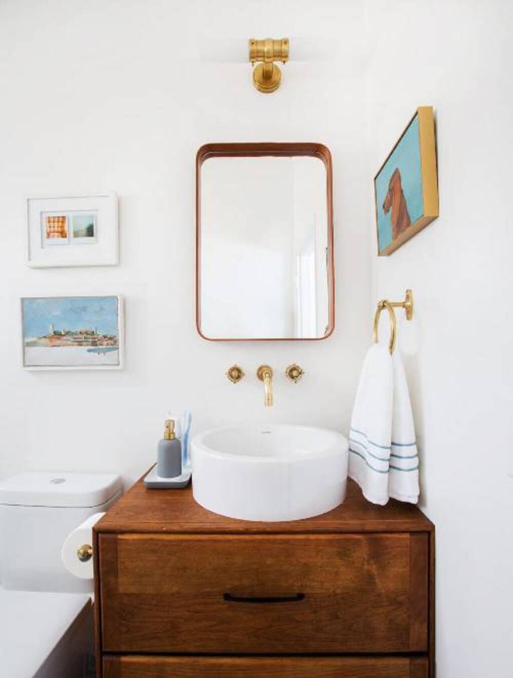 A bathroom with a sink, mirror, and toilet
