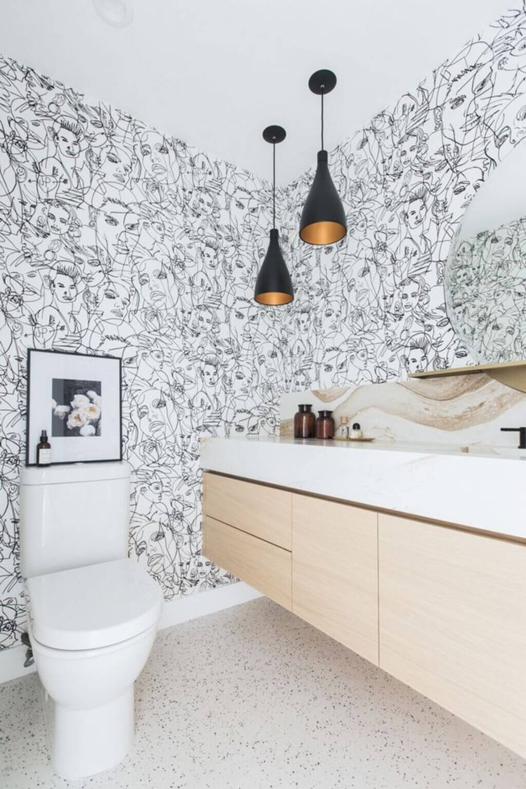 A bathroom with a toilet, sink, and Wallpaper with Prints
