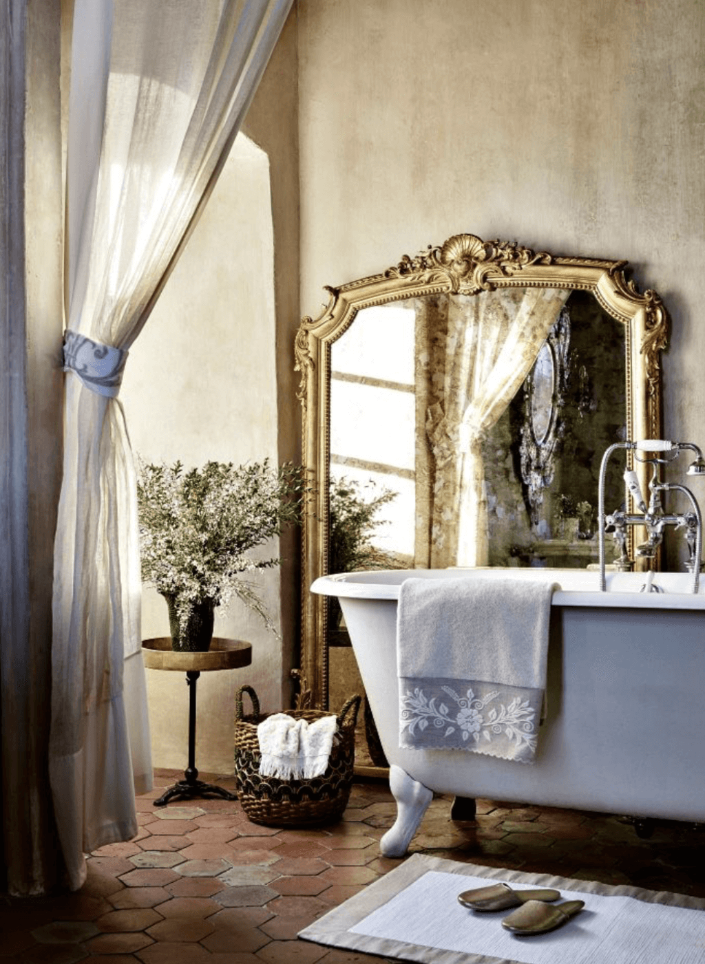 A bathroom with a large mirror and a claw foot tub
