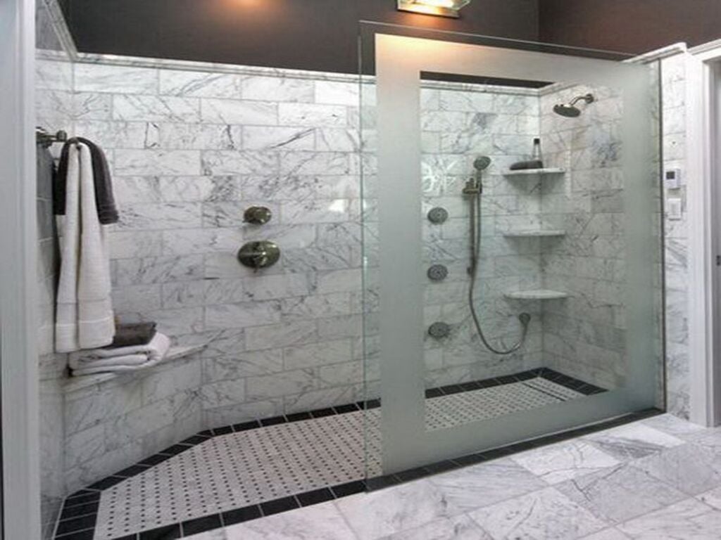 A bathroom with a walk in shower next to a sink
