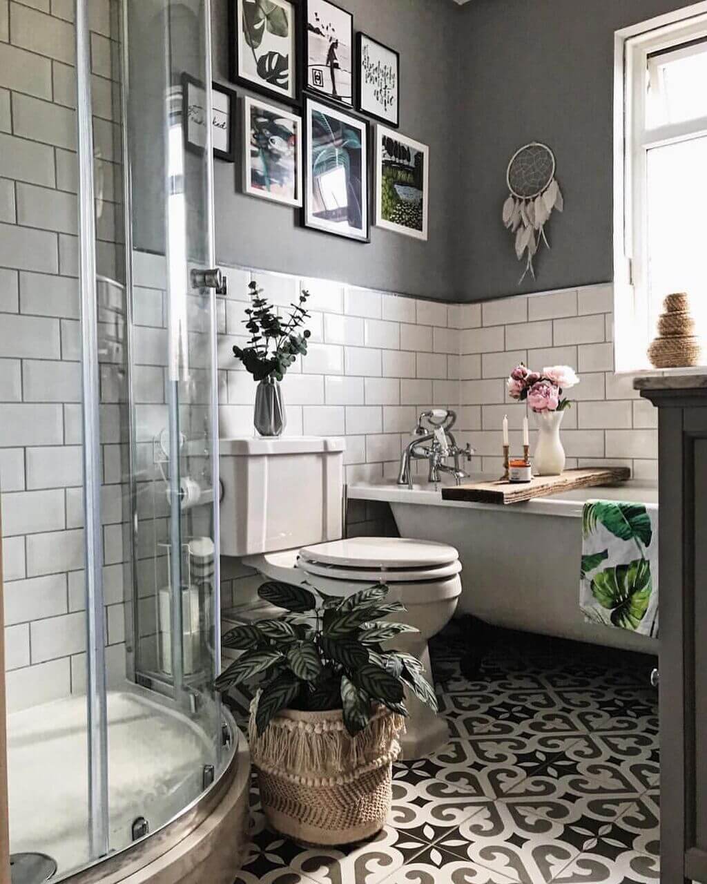 A bathroom with a tub, toilet, sink and pictures on the wall

