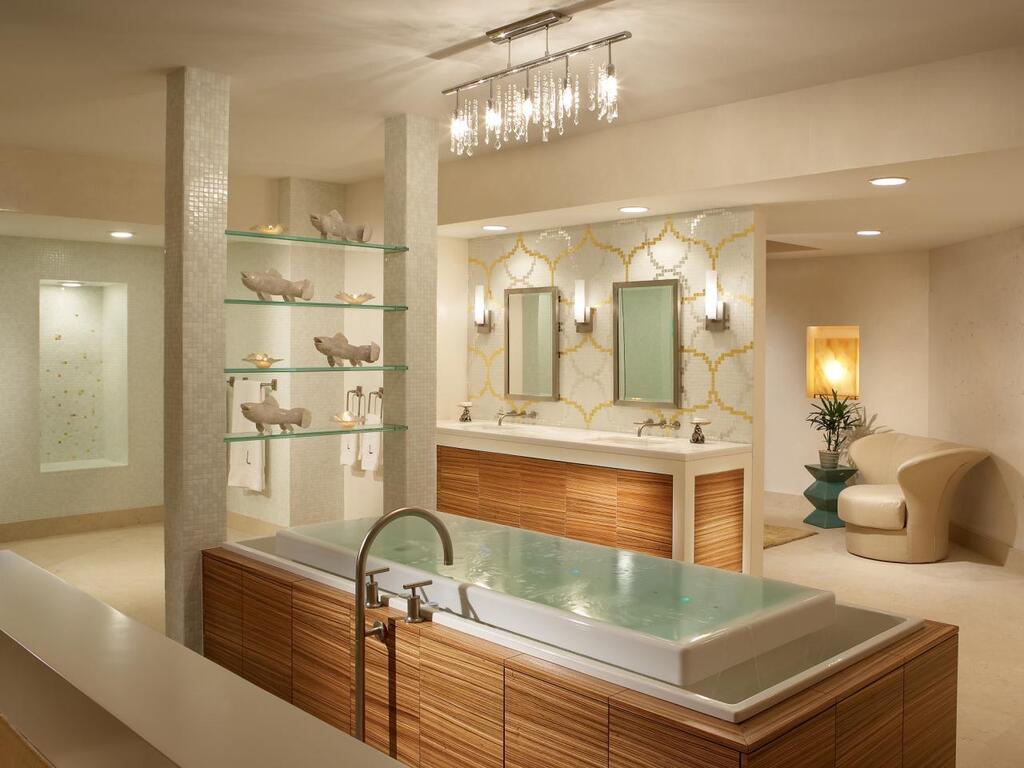 A bathroom with a large jacuzzi tub and a chandelier
