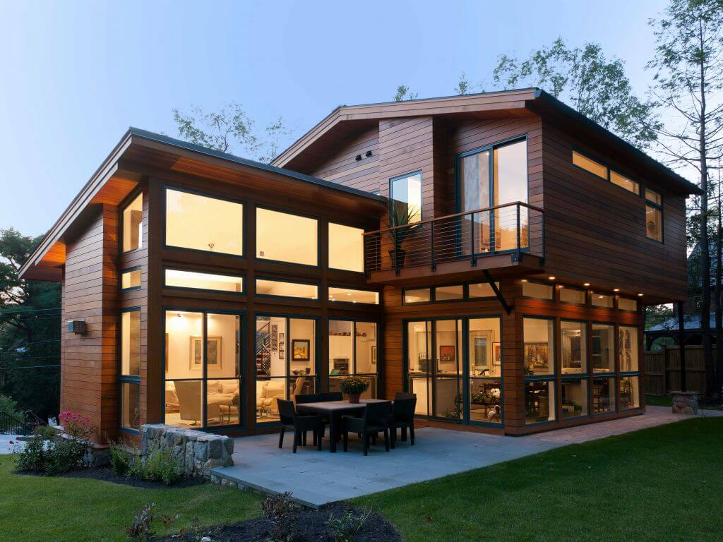 A modern house with a large deck and glass walls
