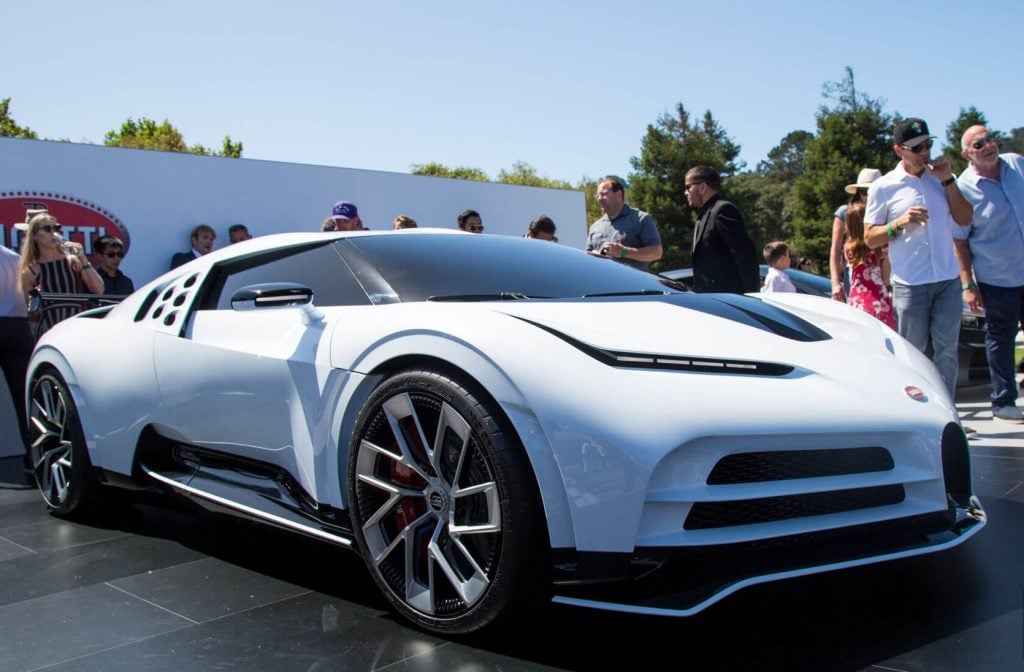 A white Bugatti Centodieci car parked in front of a crowd of people
