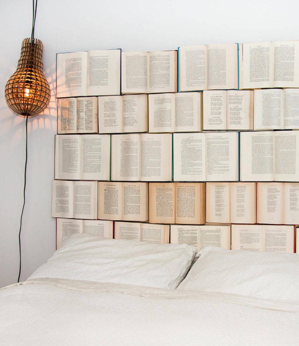 A headboard made out of books on a wall

