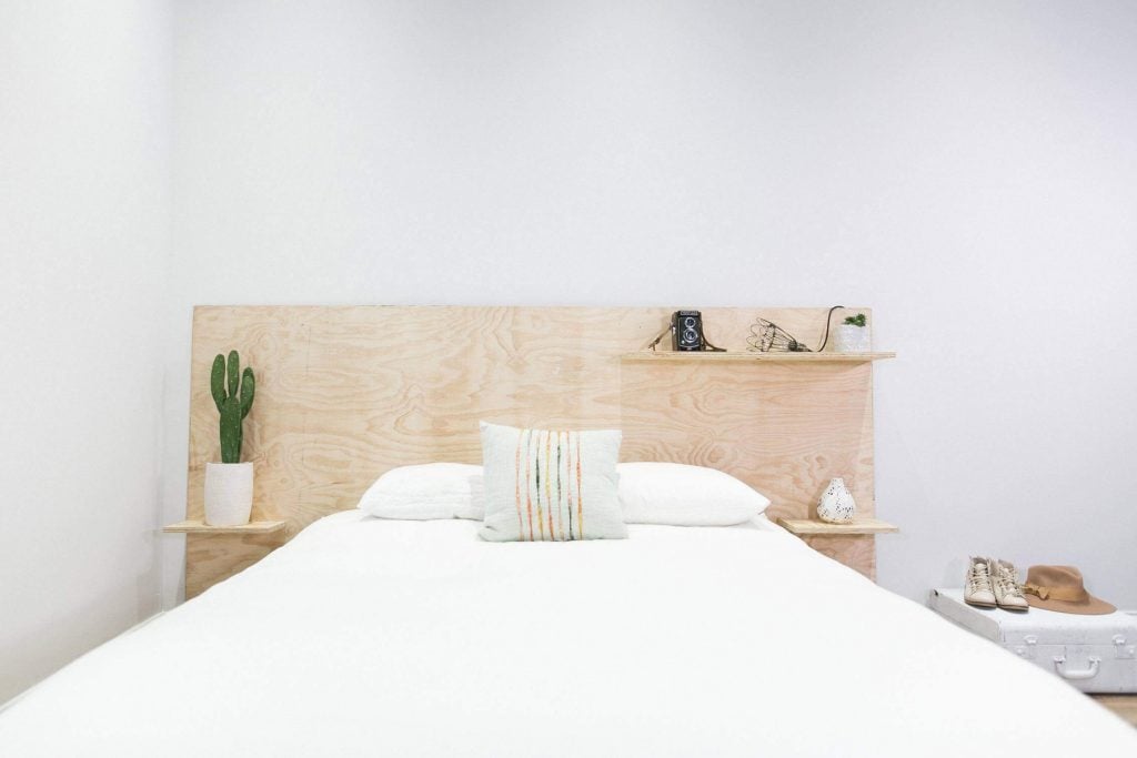 A white bed with a wooden head board
