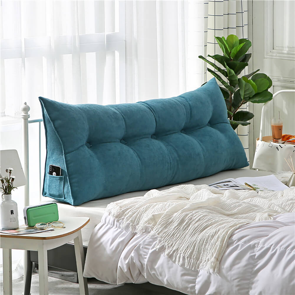 A bed with a blue pillow on top of it
