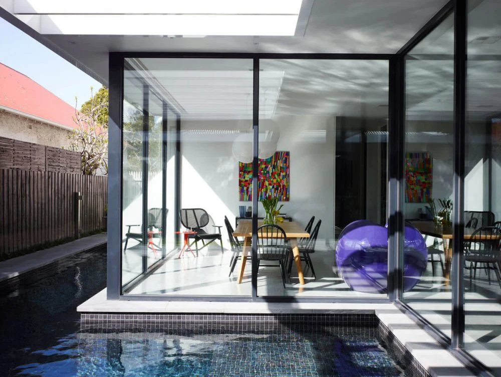A house with a pool and glass doors.