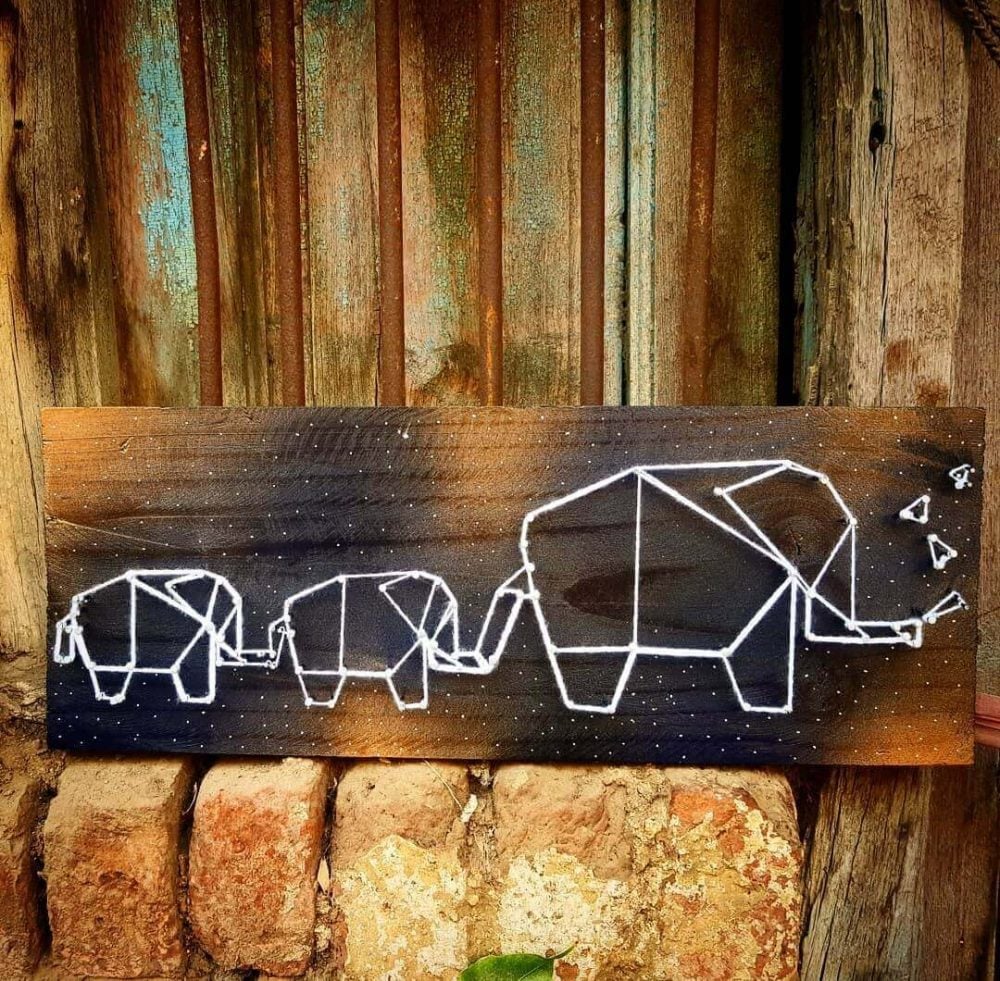 A wooden sign with a picture of elephants on it
