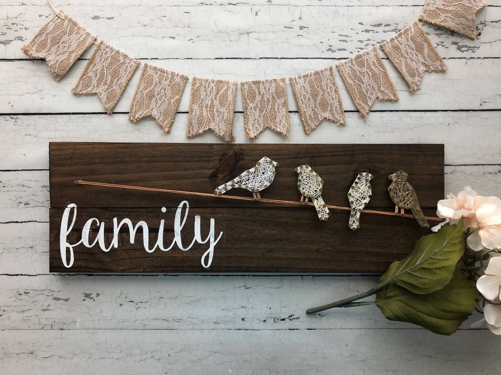 A wooden sign that says family with birds on it

