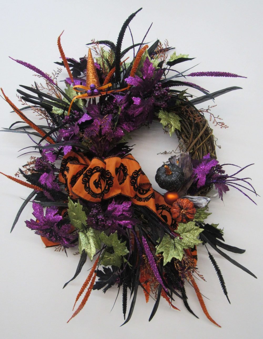 A wreath with purple and orange flowers and leaves
